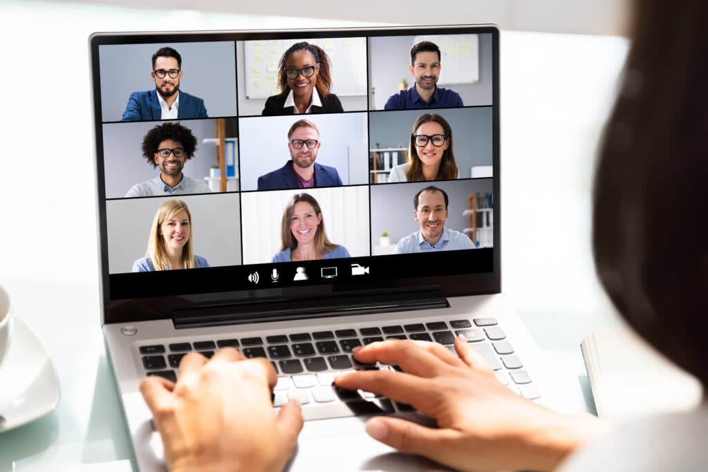 Person am Laptop in einer Videokonferenz mit neun Teilnehmenden