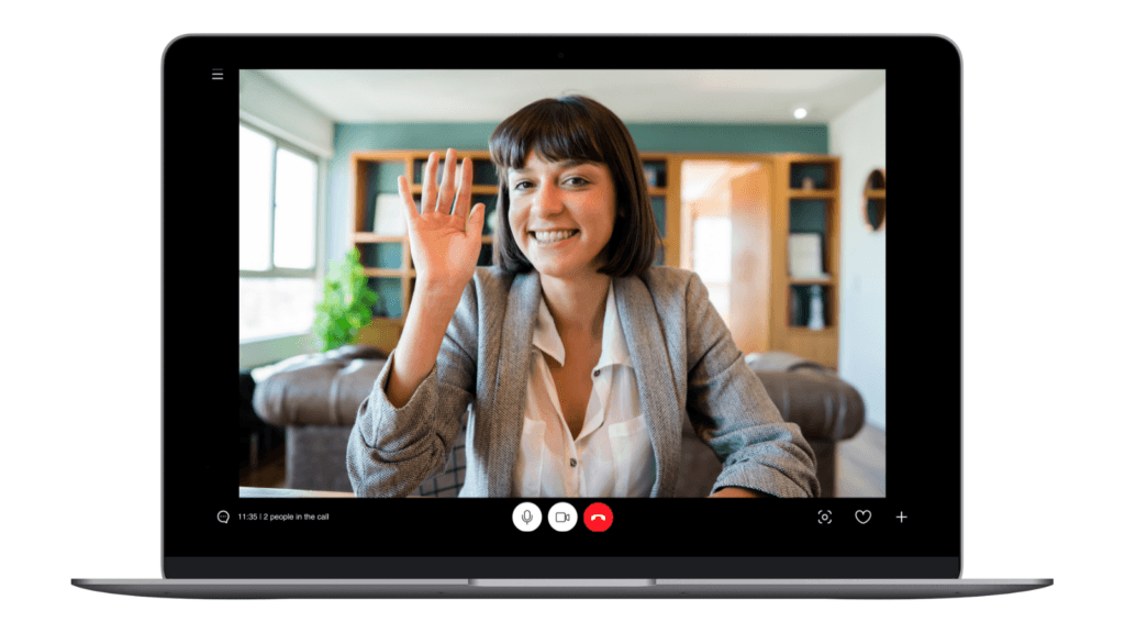 Laptop mit laufendem Videocall: Eine lächelnde Frau winkt in die Kamera